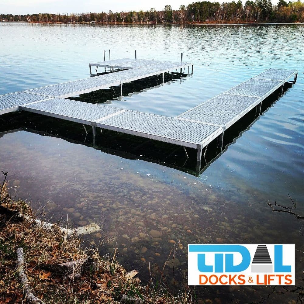 Steel dock on calm lake water surrounded by trees, featuring LIDAL Docks & Lifts branding.